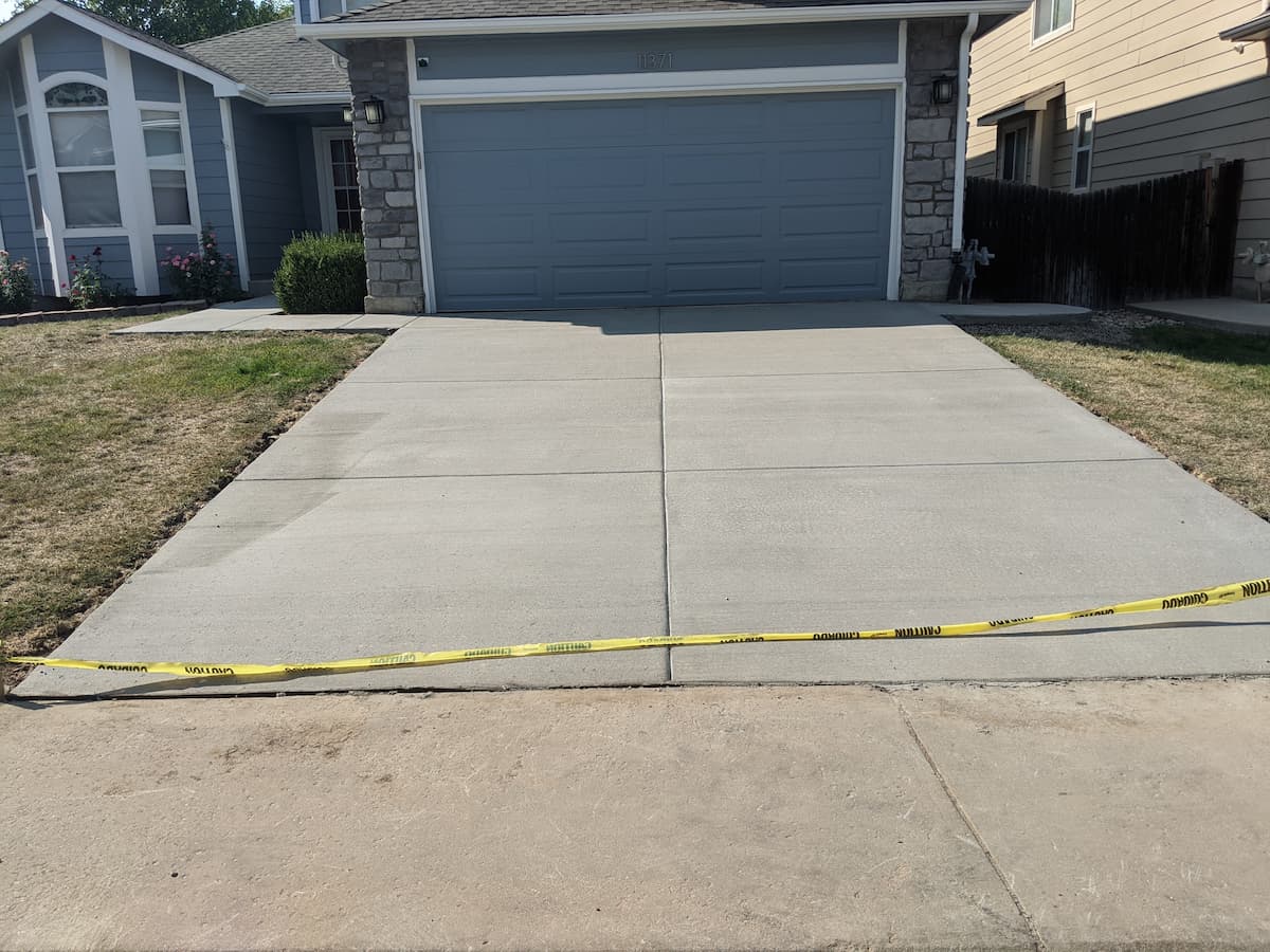 Freshly poured concrete driveway with broom finish and control joints at residential home in Des Moines Iowa by Black Ridge Contracting
